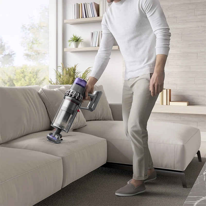 Dyson Outsize Extra cordless stick vacuum cleaner used on sofa surface